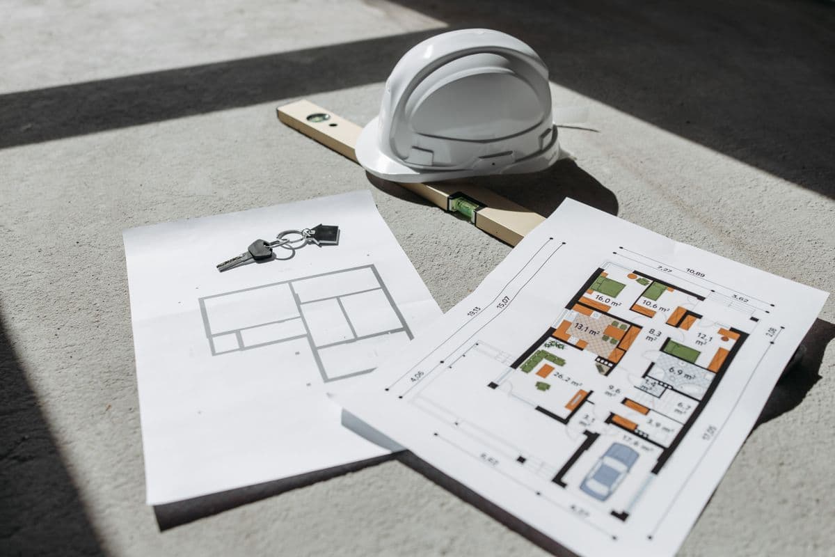 Construction site blueprints and a hard hat on a contractor's table